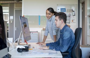 twee mensen achter een computer aan het werk